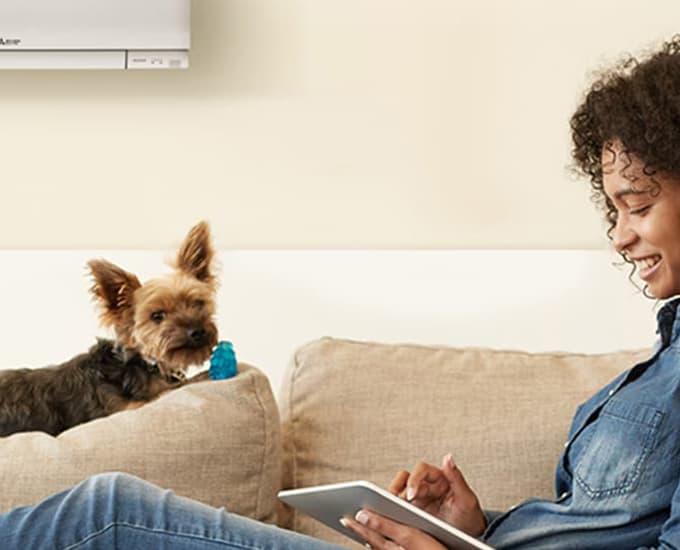 Woman on couch with heat pump on wall